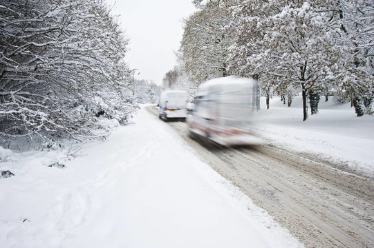 道路上的深冬季積雪與模糊移動(dòng)汽車