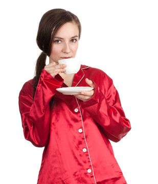 上午-年輕女子在紅色的睡衣與白色的杯子喝咖啡或TEE