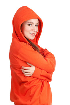 站在橙色運動衫和帽子的頭與雙臂的年輕女子