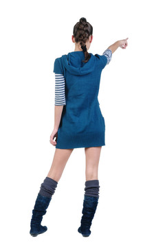 美麗的年輕女子在衣服指著墻壁。后視圖。