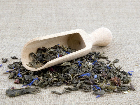 亞麻背景的綠茶和木鏟