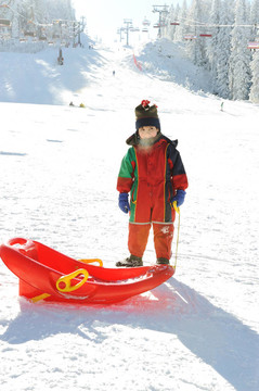 孩子在雪地上；冷凍的氣息從他口中：）