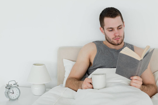 男人一邊喝茶一邊看書