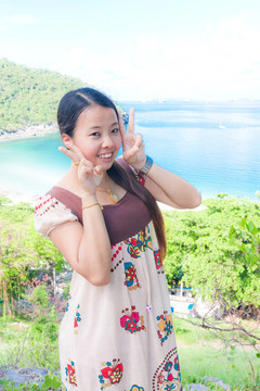 亞洲女人在海中伸出兩個手指