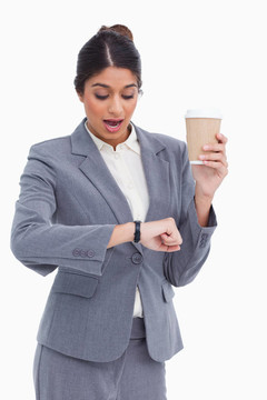 震驚的女企業(yè)家用紙杯看著她的手表