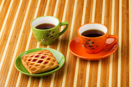 茶葉在明亮的杯子和泡芙面包果醬果醬。