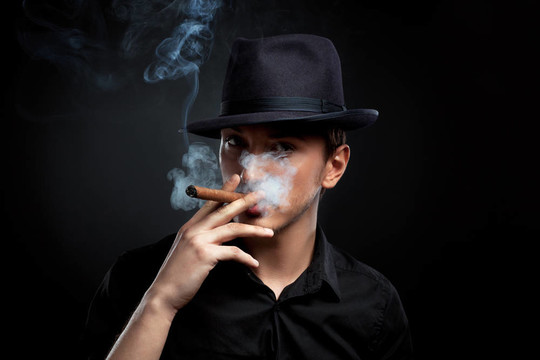 歹徒看。戴帽子和雪茄的男人。