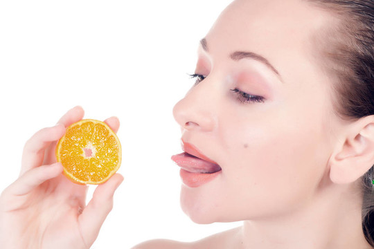 幸福的模特?cái)[著一片多汁的橘子