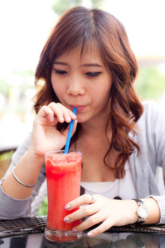 女人喝水果搖。