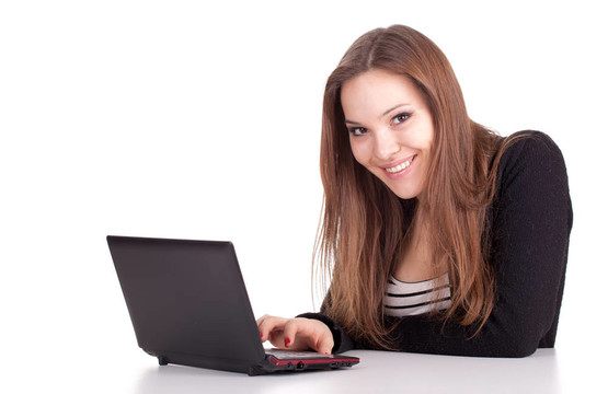微笑；年轻的棕色头发女人与笔记本电脑