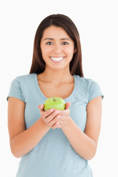 漂亮的女人拿著一個(gè)綠色的蘋(píng)果
