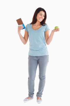 漂亮的女人拿著巧克力和蘋(píng)果