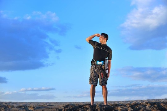 一個年輕人在海灘上的日落kitsurf肖像