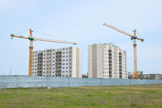 在未完工的公寓樓上方建造起重機(jī)。