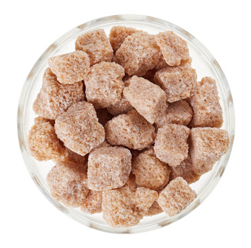 布朗塊蔗糖在一個(gè)玻璃碗；孤立的白色