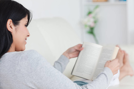女人躺在沙發(fā)上看書