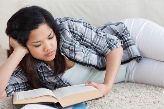 女人躺在地板上看書