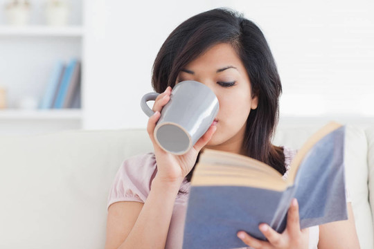 拿著書(shū)喝著杯子的女人