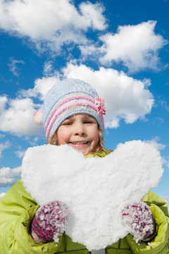 微笑的小女孩手牽手雪花心在冬日天空拼貼