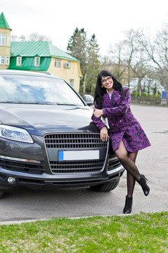漂亮的女人在附近擺上昂貴的汽車