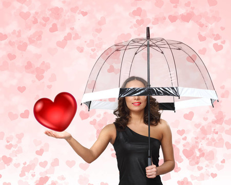 漂亮的年輕女人帶著雨傘和心