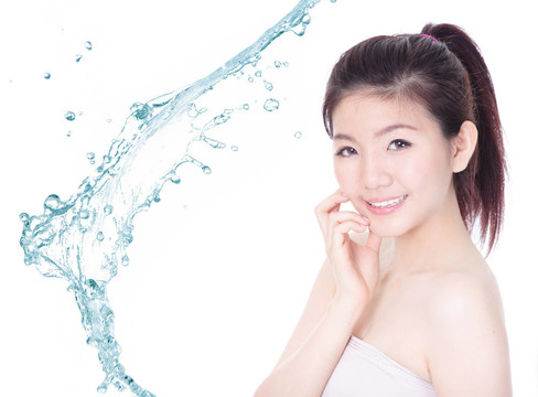 年輕女子臉上帶著飛濺的護(hù)膚露
