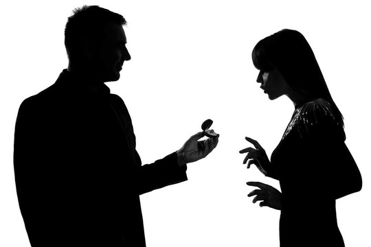 一個(gè)白人夫婦男子提供訂婚戒指和女人驚訝的工作室剪影孤立在白色背景