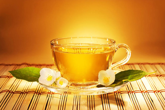 茉莉花茶在柔和溫暖的傍晚燈與新鮮茉莉花和葉子