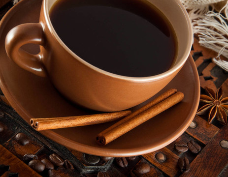 杯在田莊背景咖啡；咖啡粒和肉桂