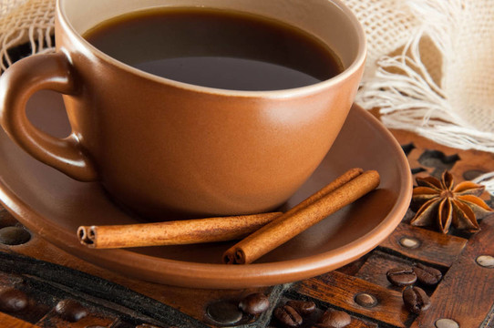 杯在田莊背景咖啡；咖啡粒和肉桂