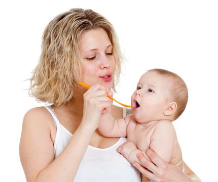 母親用勺子喂她的嬰兒