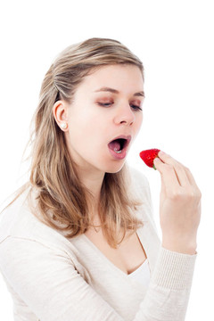 美麗的女人吃草莓