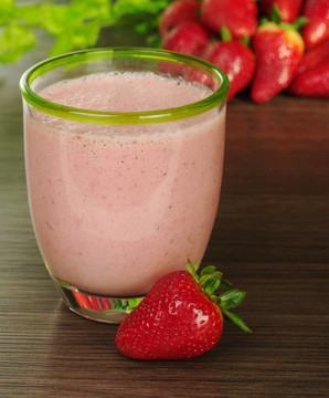 背景中的草莓葉Strawberry milkshake（選擇性聚焦；在玻璃和鏡子前面的草莓前緣焦點(diǎn)）