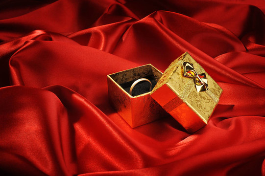 帶紅色絲綢結(jié)婚戒指的金盒子