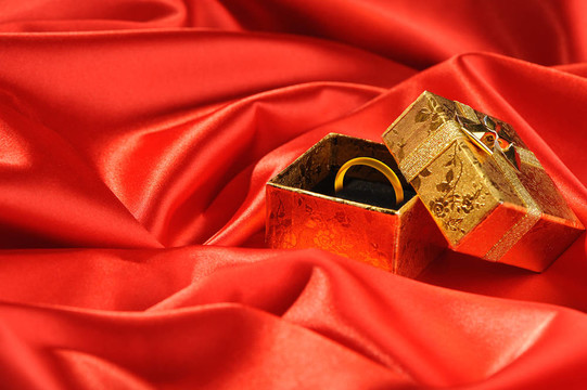 帶紅色絲綢結(jié)婚戒指的金盒子