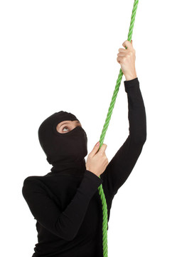 在黑色的衣服和帽子上的綠色繩女小偷