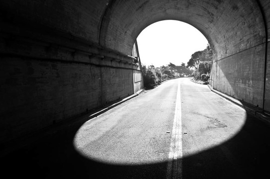 在一條黃色條紋的公路下的隧道