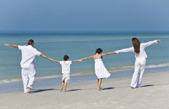母親和父親和孩子們在Beach手牽手