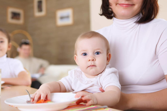 一個年輕的母親在家喂她的嬰兒