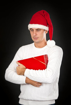 悲傷的男人在一頂帽子Santa的禮物