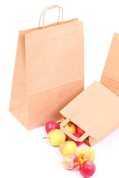 購(gòu)物棕色禮品袋和蘋(píng)果隔離