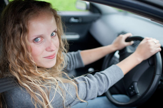 漂亮的年輕女人駕駛她的新車