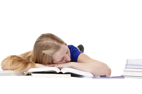 年轻漂亮女学生躺在地板上看书