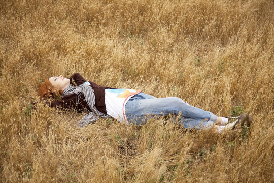 年轻美丽的姑娘躺在黄秋地。