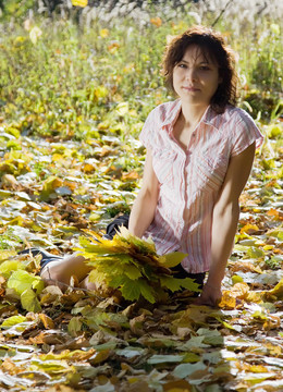 坐在秋天的公園里的女孩