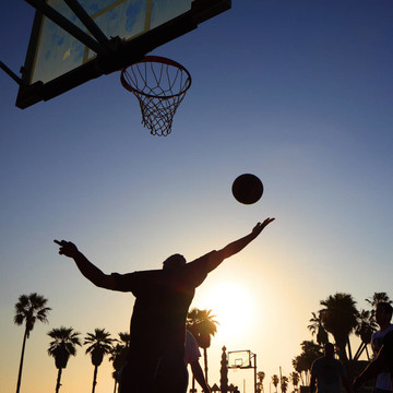 夕陽下的籃球運動員剪影
