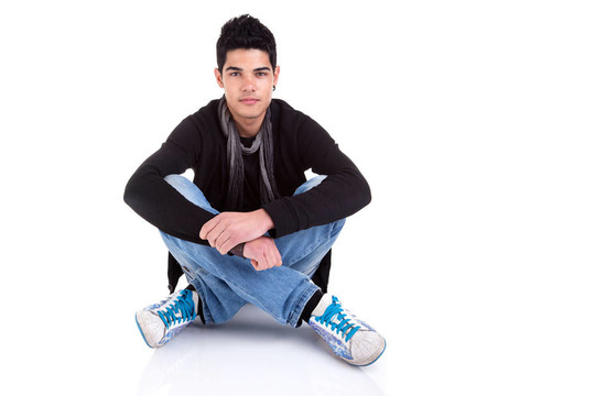 英俊的Young Man Sitting在地板上
