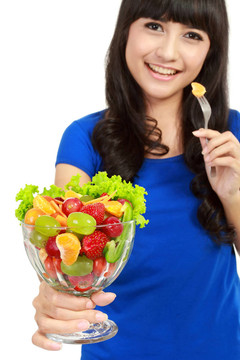 漂亮女孩吃水果沙拉；健康新鮮早餐；節(jié)食和保健理念。在白色的背景