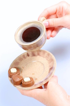果仁巧克力；杯；黑咖啡和女性手上白色
