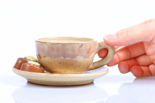 果仁巧克力；杯；黑咖啡和女性手上白色